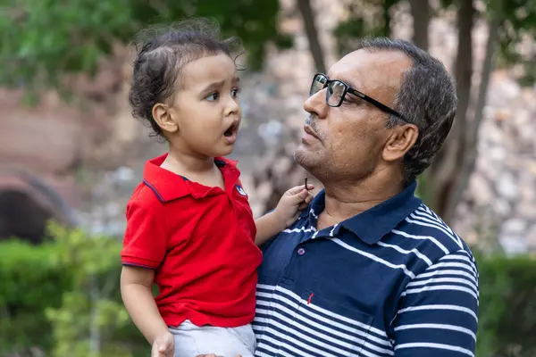 stock image Grandfather and Grandson Bonding in Outdoor Park at Dusk