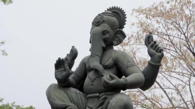 İzole edilmiş kutsal tanrı Ganesha putu gün ışığında parlak gökyüzü arka planına sahip kilden yapılmıştır.