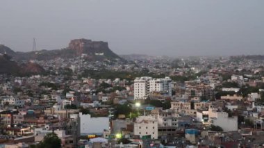 Kalabalık şehir manzaralı beton yoğun evler ve Dusk 'taki Mountain Peak' ten tarihi kale Pachetia Hill Jodhpur Rajasthan 'dan alınmıştır..