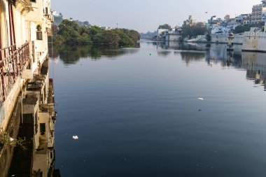 Udaipur rajasthan Hindistan 'da, Tarihi Mimari ve Yansımalı Şehrin Huzurlu Rıhtım Görünümü çekilmiştir.