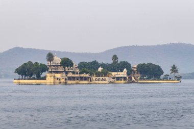 Udaipur Rajasthan Hindistan 'da sabah görüntüsünde dağlık arka planda el değmemiş gölde sanatsal mimari çekiliyor..