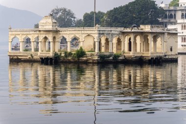 Udaipur Rajasthan Hindistan 'da sabah görüntülerinde el değmemiş gölde sanatsal saray mimarisi çekiliyor..