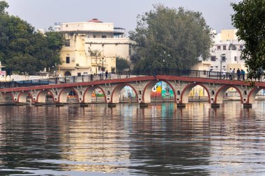 Huzurlu bir sabah Udaipur 'un Huzurlu Göl üzerindeki tarihi kemerli köprüsünde su görüntüsü Udaipur Rajasthan Hindistan' da çekildi..
