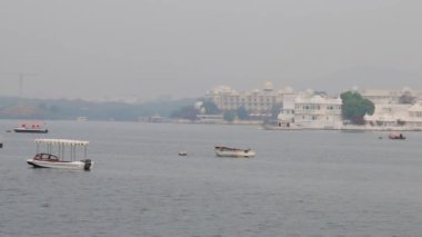 Udaipur Rajasthan Hindistan 'da sabah videosu çekilen el değmemiş göldeki tekneler..