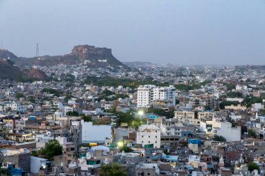 Kalabalık şehir manzaralı beton yoğun evler ve Dusk 'taki Mountain Peak' ten tarihi kale Pachetia Hill Jodhpur Rajasthan 'dan alınmıştır..