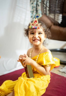 little indian baby boy in holy hindu god kirshna attire at indoor clipart