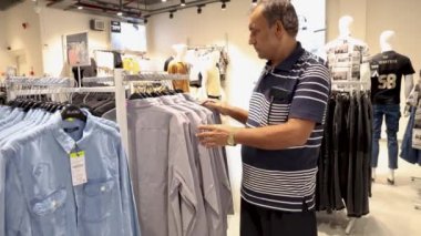 Alışveriş merkezinde kıyafet seçen adam videosu, 20 Temmuz 2024 'te alışveriş merkezi trendleri Jodhpur Rajasthan Hindistan' da çekildi..