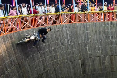 daredevils biker stunt at well of death or maut ka kuan show at evening video is taken at jodhpur local fair rajasthan india on Aug 19 2024. clipart