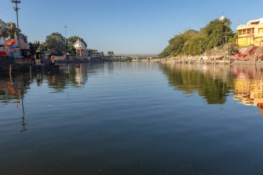 Eski tapınağı ve parlak mavi gökyüzü olan el değmemiş kutsal Shipra nehri kıyısı sabah vakti Mar 09 2024 'teki Ujain Madhya Pradesh Hindistan' ında görüntülenir..