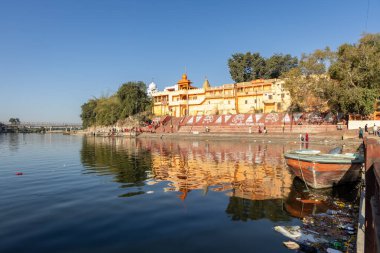 Eski tapınağı ve parlak mavi gökyüzü olan el değmemiş kutsal Shipra nehri kıyısı sabah vakti Mar 09 2024 'teki Ujain Madhya Pradesh Hindistan' ında görüntülenir..