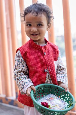 isolated cute kid devotee with holy offering at temple in indian traditional dress clipart