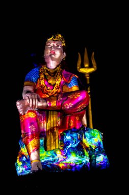 Statue of Hindu God Lord Shiva Ardhnarishwar in Meditation Posture with dramatic laser light effect clipart