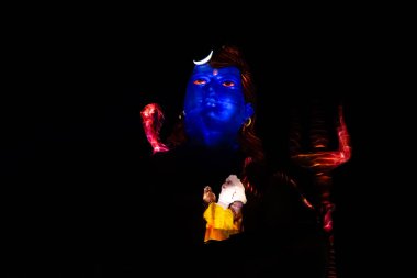 Hindu Tanrısı Shiva 'nın izole edilmiş heykeli dramatik lazer ışığı efektiyle nezaket tasvir ediyor.