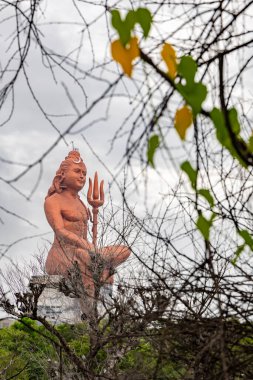 Hindu Lord Shiva 'nın izole edilmiş heykeli. Meditasyon Duruşu. Eşsiz bir bakış açısıyla dramatik bir gökyüzü.