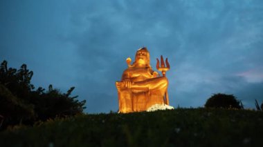 Kutsal Hindu Tanrısı Shiva 'nın izole edilmiş heykeli dramatik gökyüzü ile Meditasyon Duruşu