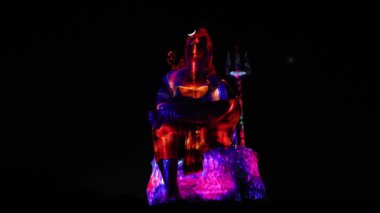 Hindu Lord Shiva 'nın izole edilmiş heykeli dramatik lazer ışığı efektiyle ruhun uyanışını tasvir ediyor.