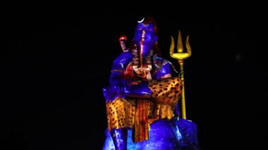 Hindu Lord Shiva 'nın izole edilmiş heykeli dramatik lazer ışığı efektiyle ruhun uyanışını tasvir ediyor.