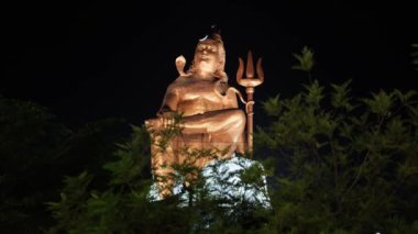 Kutsal Hindu Lord Shiva 'nın izole edilmiş heykeli Meditasyon Duruşu ve gece karanlık gökyüzü