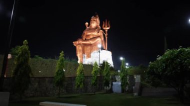 Kutsal Hindu Lord Shiva 'nın izole edilmiş heykeli Meditasyon Duruşu ve gece karanlık gökyüzü