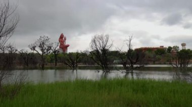 Bulut hareketi, Shiva Heykeli üzerinde meditasyon yaparken bozulmamış bir göl ve gün doğumunda parlak bir gökyüzü.