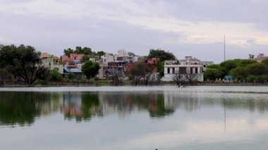 Şehir manzaralı Serene Gölü ve Parlak Gökyüzü Altında Su Yansımaları