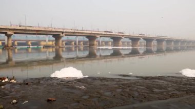 Kirli nehir, endüstriyel ve yerli akışkan maddelerle dolu zehirli köpük ve yol köprüsü sabah videosu yamuna River okhla barrage delhi Hindistan 'da çekiliyor..