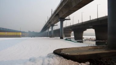 Kirli nehir, endüstriyel ve yerli akışkan maddelerle dolu zehirli köpük ve yol köprüsü sabah videosu yamuna River okhla barrage delhi Hindistan 'da çekiliyor..
