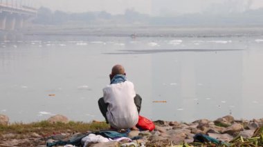Kirli Nehir kenarında Sabahları Zehirli Köpükle Oturan İzole Adam, Yamuna Nehri Okhla Barrage Delhi Hindistan 'da çekiliyor..