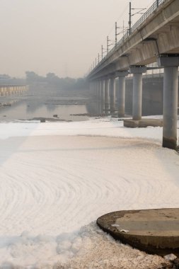 Kirli nehir, endüstriyel ve yerli akışkanlar zehirli köpük ve yol köprüsü ile sabah görüntüsü yamuna Nehri Okhla Barrage Delhi Hindistan 'da çekilmiştir..