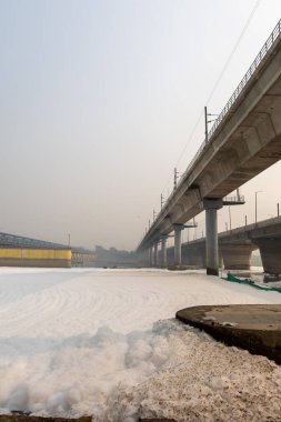 Kirli nehir, endüstriyel ve yerli akışkanlar zehirli köpük ve yol köprüsü ile sabah görüntüsü yamuna Nehri Okhla Barrage Delhi Hindistan 'da çekilmiştir..