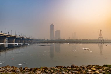 Foggy City 'de yol köprüsü, endüstriyel ve yerli akışkanlar, Kirli Nehirde Zehirli Köpük dramatik gündoğumu görüntüsü, yamuna Nehri Okhla Barrage Delhi Hindistan' da çekildi..