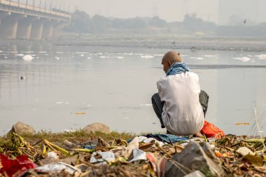 Zehirli Köpükle Kirletilmiş Nehir 'e bakan izole bir adam sabah görüntüsü yamuna Nehri Okhla Barrage Delhi Hindistan' da çekildi..