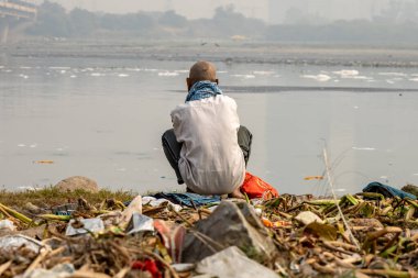 Zehirli Köpükle Kirletilmiş Nehir 'e bakan izole bir adam sabah görüntüsü yamuna Nehri Okhla Barrage Delhi Hindistan' da çekildi..