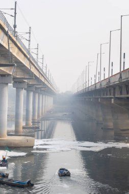 Çağdaş Yol Köprüsü Zehirli Köpük ve İşçi Teknesi ile Kirlenmiş Nehir Bulutlu Sabah Videosu yamuna Nehri Okhla Barrage Delhi Hindistan 'da 4 Kasım 2024' te çekildi..