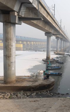 Çağdaş Yol Köprüsü Zehirli Köpük ve İşçi Teknesi ile Kirlenmiş Nehir Bulutlu Sabah Videosu yamuna Nehri Okhla Barrage Delhi Hindistan 'da 4 Kasım 2024' te çekildi..