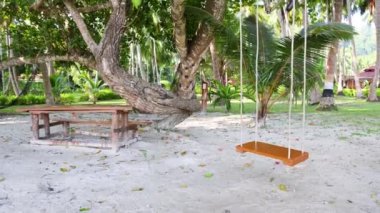 Sabahları turistler için kumsalda salıncakta sallanmak