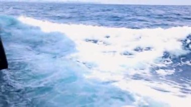 Gündüzleri sakin denizde su sıçrayan gemiler.