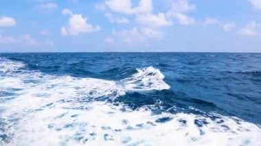 Gündüzleri sakin denizde su sıçrayan gemiler.