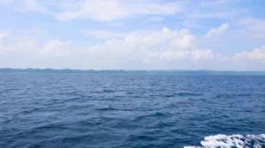 Parlak mavi gökyüzünün altında gün ışığında el değmemiş deniz manzarası