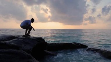 Kala Pathar Sahili 'nde Andaman ve Nicobar Adaları' nı kasıp kavuran deniz ufkuyla şafakta dramatik bir gökyüzü ile kıyıdan uzaklaşan izole genç adam görülüyor..
