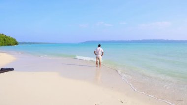 İzole edilmiş bir adam, Andaman ve Nicobar Adaları 'ndaki Havelock Adası' ndaki Radhanagar Sahili 'nde sabahın ilk ışıklarıyla el değmemiş, beyaz kumsal sahilinde çekiliyor..
