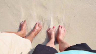 Sabah beyaz kumsalda deniz dalgaları olan evli çiftler Andaman ve Nicobar Adaları 'ndaki Havelock Adası' ndaki Radhanagar Sahili 'nde çekiliyor..