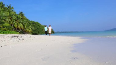 Evli çiftler, el ele tutuşup sahilde sabah saatlerinde dalgalarla dolaşırken Andaman ve Nicobar Adaları 'ndaki Havelock Adası' ndaki Radhanagar Sahili 'nde romantik bir yürüyüş gerçekleştiriliyor..