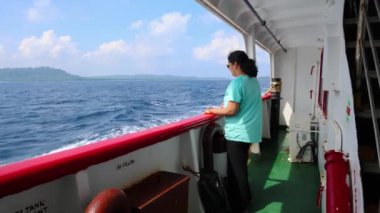 Gemi gözlem galerisinden gün ışığında deniz manzarası seyreden izole bir kız, Andaman ve Nicobar Adaları 'ndaki Havelock Adası' na giden feribot penceresinde çekiliyor..