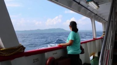 Gemi gözlem galerisinden gün ışığında deniz manzarası seyreden izole bir kız, Andaman ve Nicobar Adaları 'ndaki Havelock Adası' na giden feribot penceresinde çekiliyor..