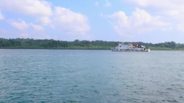 Ada kıyı şeridi boyunca canlı bir sabah gökyüzü görüntüsüyle yol alan yolcu gemisi 13 Kasım 2024 'te Havelock Adası ve Nicobar Adaları' nda çekildi..