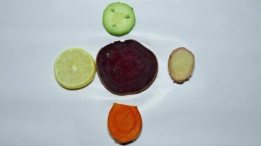 Beyaz arka planda taze çiğ zerdeçal, pancar, limon, salatalık ve zencefil.
