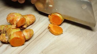 Tahtaya yakın çekimde taze çiğ zerdeçal doğrama. Arka plan stüdyosu çekimi.