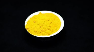 Seramik kasede taze zerdeçal tozu ve siyah arka plan stüdyoları.