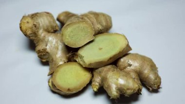 Taze zencefil dilimi, yakın çekim, bulanık beyaz arkaplan.